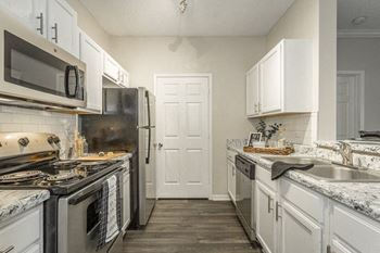 a kitchen with stainless steel appliances and white cabinets